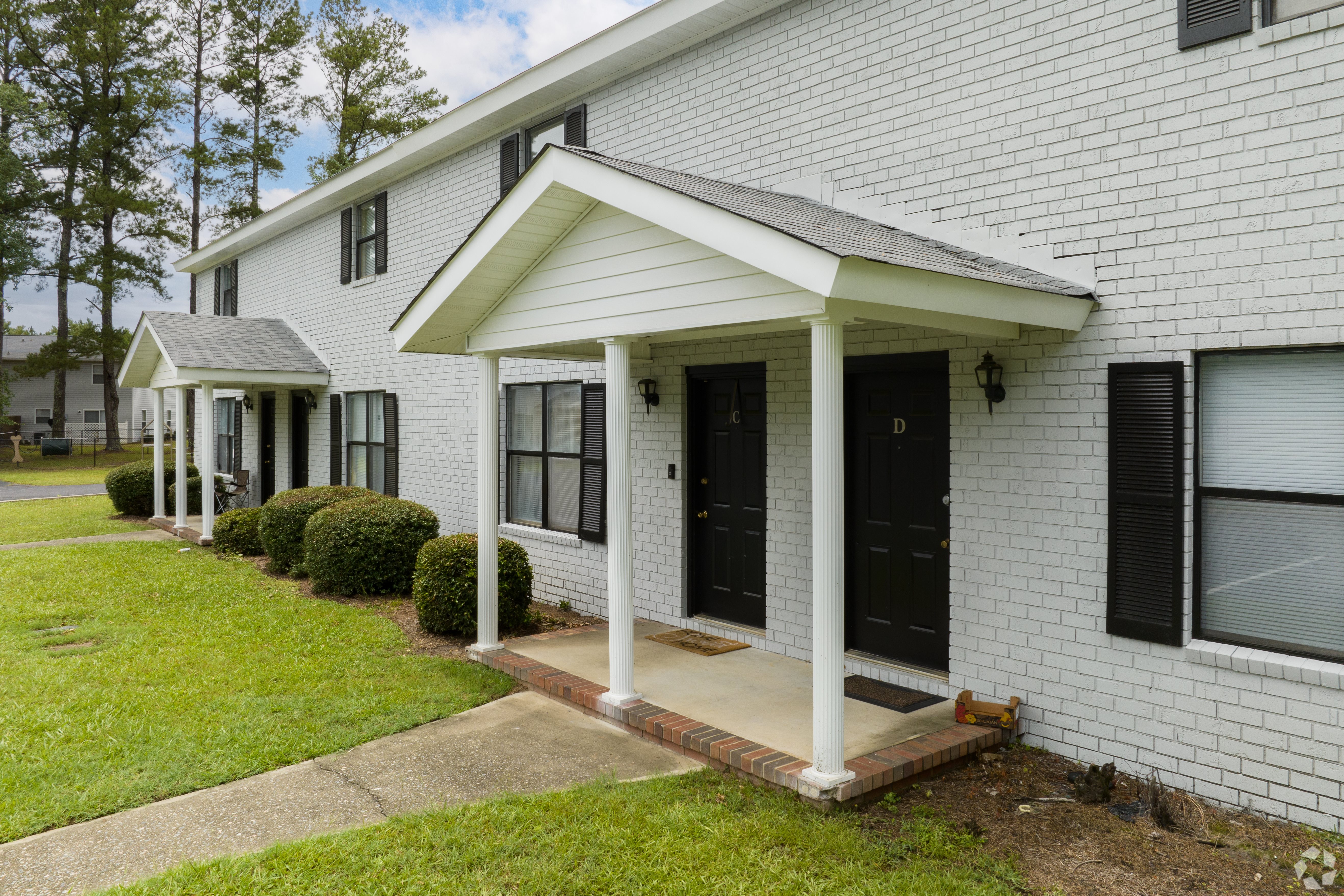 a white brick house with black doors and windows